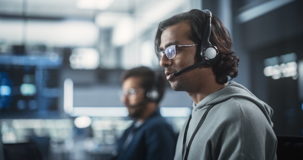 IT expert answering a call on their headset as a helpdesk associate