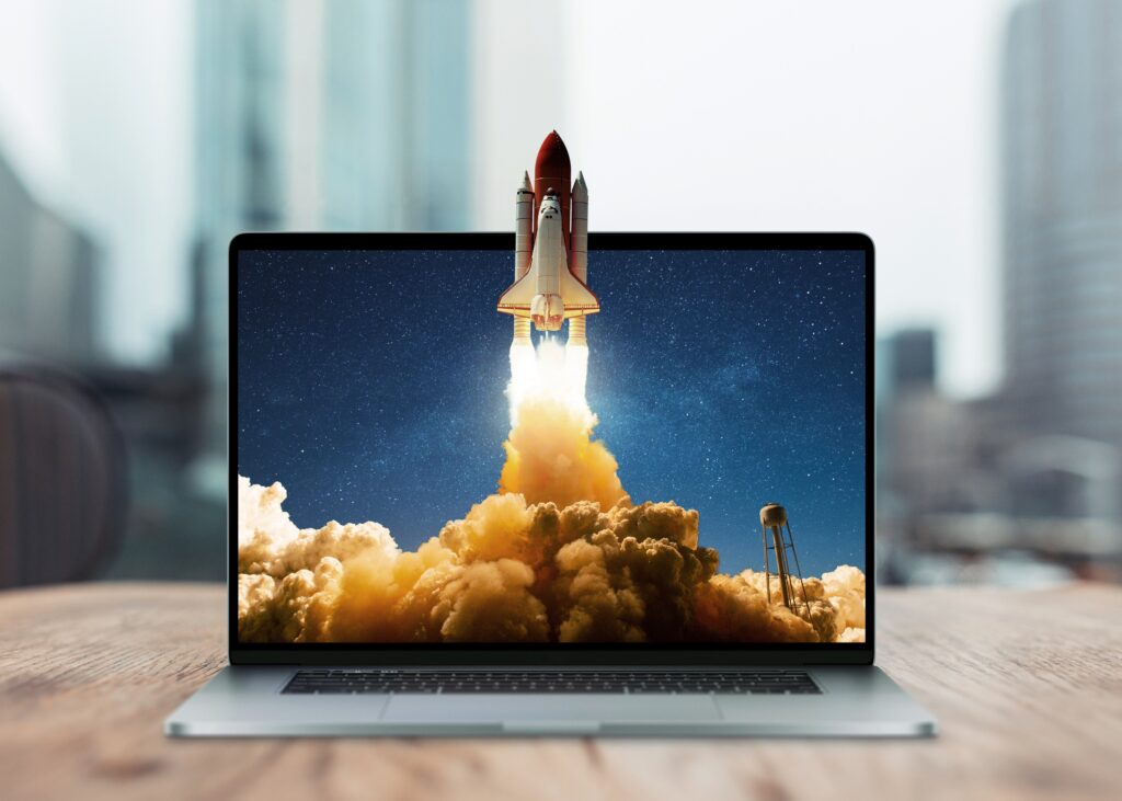 A laptop with a graphic of a rocket shooting out of it to show speed